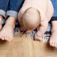 Young baby with parents feet