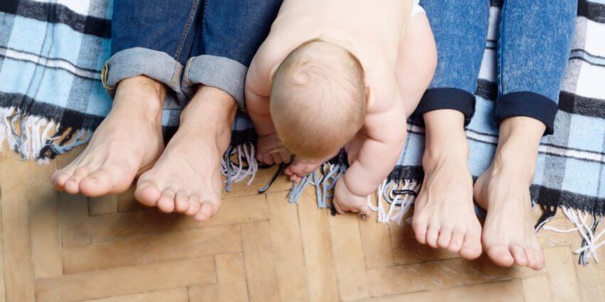 Young baby with parents feet